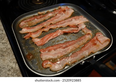 Pork Bacon slices cooking on a frying pan for breakfast. - Powered by Shutterstock