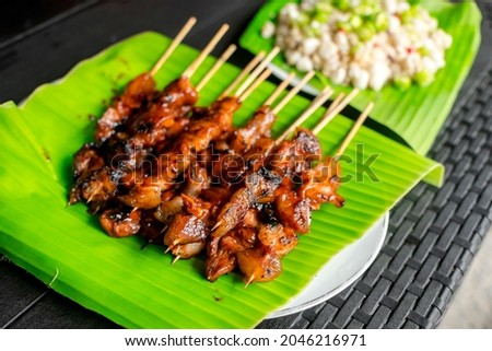 Pork Barbecue and Kinilaw na Scallops placed on banana leaves. Filipino appetizer dishes usually matched with beer.