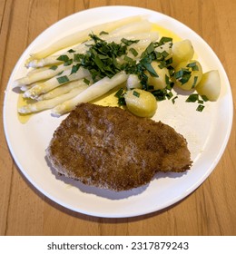 Pork chop, fresh asparagus and potatoes on wild garlic butter