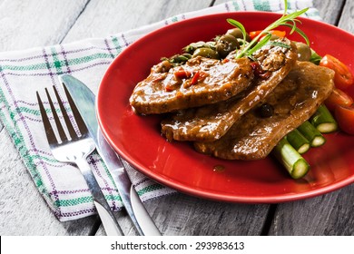 Pork Chop With Sauce And Asparagus On A Plate