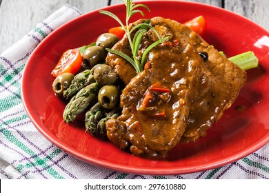 Pork Chop With Sauce And Asparagus On A Plate