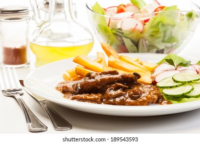 Pork Chop With Sauce, Mushrooms And Chips On A Plate