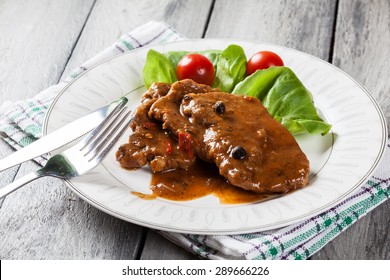 Pork Chop With Sauce And Vegetables On A Plate