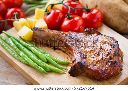 pork chop serve with vegetable on wooden board