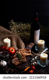 Pork Chops Steak With Black Pepper Sauce Placing On Vintage Wooden Plate Together With Many Ingredient And Wine Bottle In Dark Background