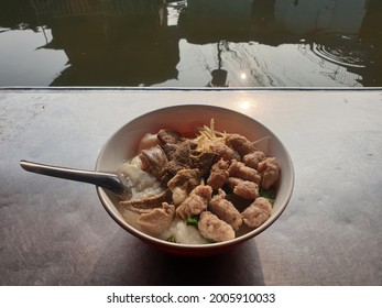 Pork Congee With A Metal Table At The Edge Of The Canal In The Morning, Local-style Pork Porridge Is Influenced By Chinese Food. Street Food At A Market In Bangkok City