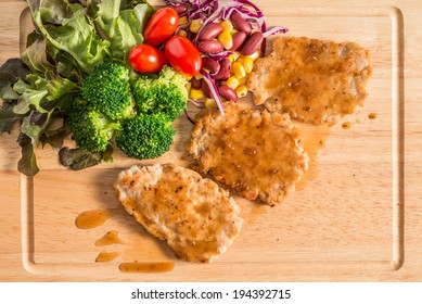 Pork Cube Steak Topped With Pepper Sauce And Creamy Salad On Wood Plate