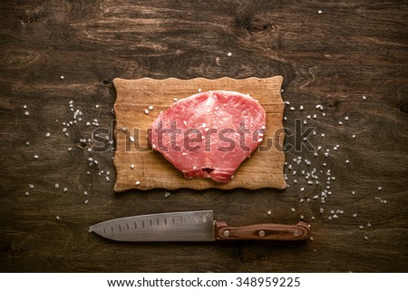 Pork cutlet. A piece of raw meat ready for preparation with spices on wooden table. Stock photo © 