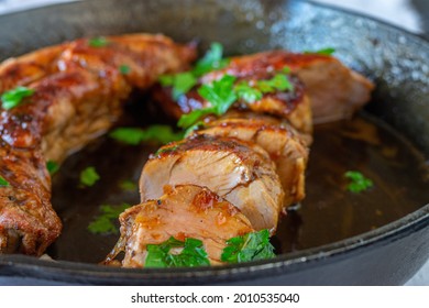 Pork fillet or tenderloin served with a delicious honey, garlic,  soy sauce in a cast iron pan - Shutterstock ID 2010535040