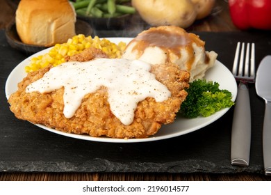 Pork Fritter And White Gravy. Table Setting With Mashed Potatoes, Corn And A Roll.