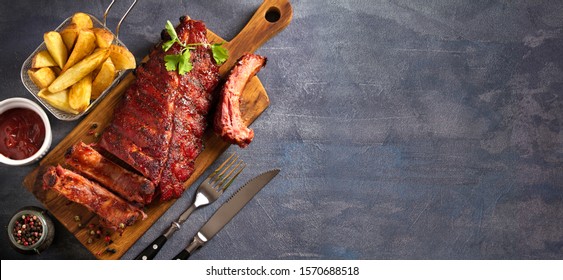 Pork Loin Ribs Served On Chopping Board And Potato Wedges. View From Above, Top. Copy Space