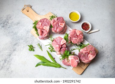 Pork Osso Buco, Shin Pork Shanks With Fresh Aromatic Herbs On White Marmol Board