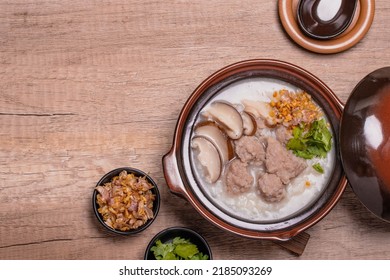 Pork porridge with shiitake mushrooms in brown cups topped with coriander and fried garlic - Shutterstock ID 2185093269