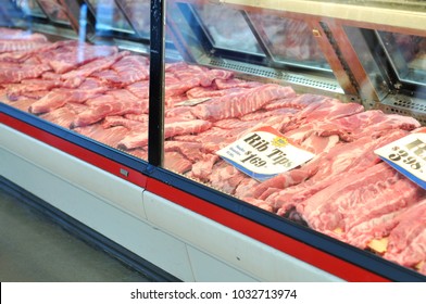 Pork Rib Tips For Sale At A Butcher Shop Meat Case Counter. Large Piles Of Raw  Pork Ribs Seen Behind Glass In A White Meat Market Refrigerated Display, With Signs And Prices.