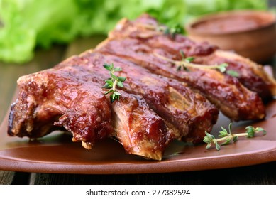 Pork Ribs With Herbs On Plate, Close Up View