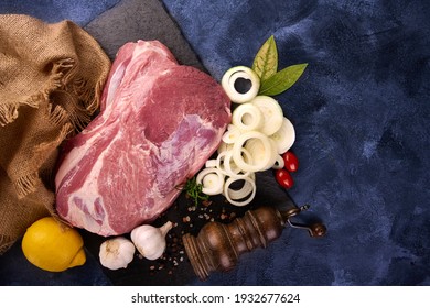 Pork Shoulder Roast With Herbs And Spices On Blue Rustic Background. High Resolution Image. With Copy Space.