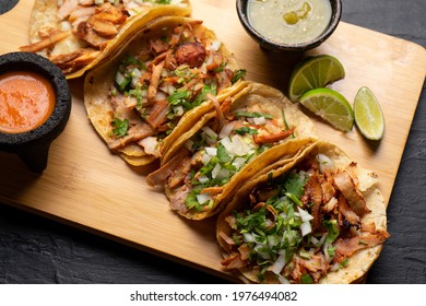 Pork tacos called al pastor with pineapple on dark background. Traditional mexican tacos - Shutterstock ID 1976494082