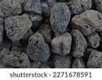 Porous black volcanic rock isolated on white background. Lava stone, pumice stone, or volcanic pumice with distinctive pores.