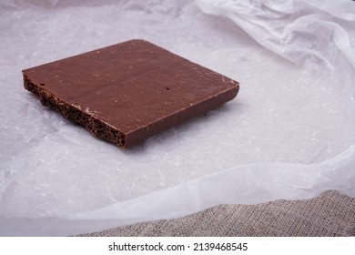 Porous Chocolate Bar On White Paper. Bubbled Or Spongy Chocolate, Tasty Sweets, Carbohydrate Food, Sweet Temptation, Unhealthy Diet