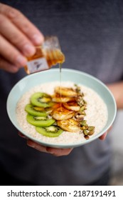 Porridge With Caramelized Bananas, Kiwi, Seeds And Honey Drizzle.