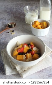 Porridge Made Of Instant Arrowroot Flour In A White Bowl With Mango, Almond, Strawberry And Raisin