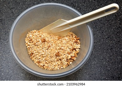 Porridge Oats And Nuts In A Plastic Mixing Bowl With A Spatula