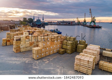 Port area with wooden cargo stacked in piles and ready for export.