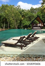 Port Douglas, Queensland Australia, March 2014: Beautiful Inground Swimming Pool With Invisible Glass Fencing With Tropical Bush In The Background