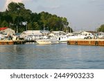 Port Dover, Ontario, Canada. Lake Erie, Great Lakes. Marina, pier. Boat, boats, boating. Sailboat sailboats. Summer, sky, trees. Calm water. Moored anchored dock docked. 