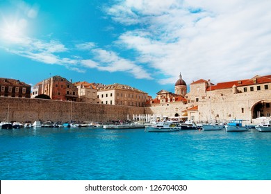 Port Of Dubrovnik From Water In Sunny Day With Boats Parked To The Peer