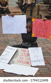 Port Elizabeth, South Africa - September 2019: A Young Black Woman Sitting With Feminist Signs At A Protest To Remember Women Who Were Raped And Killed In South Africa.