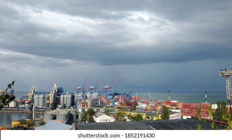 Port with grain elevators and stack container area. Industrial seascape view under stormy clouds in high sky. Maritime landscape in harbor of European Black sea coast