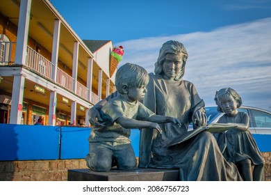 Port Jefferson, New York-November 4, 2021:   25th Annual
Charles Dickens Festival, A Statue Of The Mother Reading Book With Her Son And Daughter