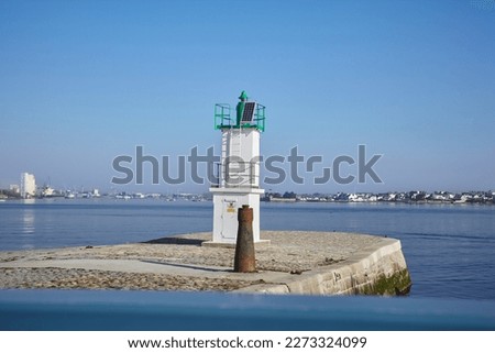 Port Louis, Bretagne, France : Beautiful little lighthouse by the sea, Lorient view in the background, lots of colors, very sunny day