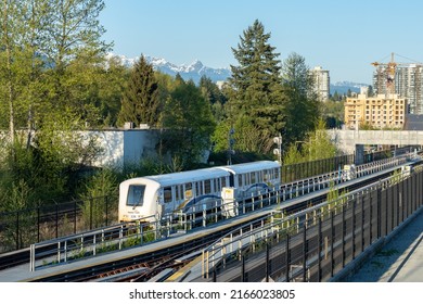 Port Moody, BC, Canada - April 20 2021 : Millennium Line SkyTrain. Moody Centre Station. City Skyline And Nature Landscape In The Background. Urban Transportation Concept.