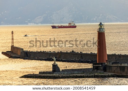 Port of Naples,Italy.Early morning view of the lighthouse on the island of St. Vincenzo,mentioned in documents in 1268 and statue of San Gennaro-the patron Saint of Naples,made in the mid 17th century