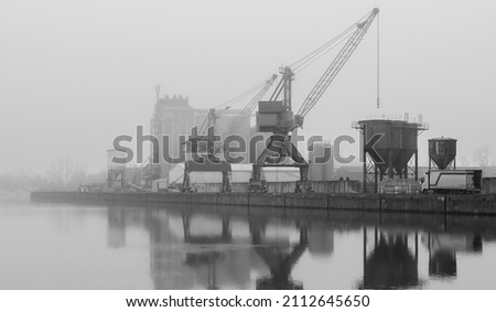 Pastel evening atmosphere at the harbor basin with cargo cranes