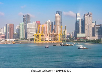 port of singapore with its unloading cranes freighters and in the background the buildings of the city of singapore
