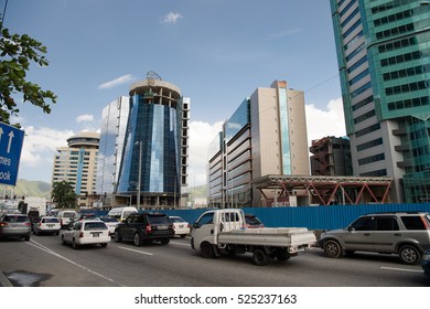 Port of spain, Trinidad and Tobago - November 28, 2015: city road with transport and modern buildings with glass facade in town on blue sky on streetscape background