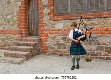 Port Stanley, Falkland Islands - November 20, 2017: A Little Boy Playing Pipes Wearing A Typical Kilt.