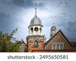 Port Sunlight, Wirral, UK - July 26th 2024 -The lead domes and a bell on the roof tops of a school on top of a clock tower