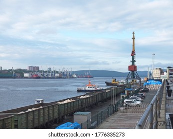 Port of Vladivostok cargo terminal pier with tugboat, big cranes and railroad with Freight cars