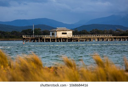 PORT WELSHPOOL, VICTORIA, AUSTRALIA - 06 APRIL 2018: Remnant Structure Of The Derelict Long Jetty At Port Welshpool In Corner Inlet, Stark Against Wilsons Promontory National Park In The Distance.