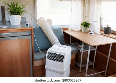 Portable air conditioner unit operating inside a modern camper van during a summer heatwave
