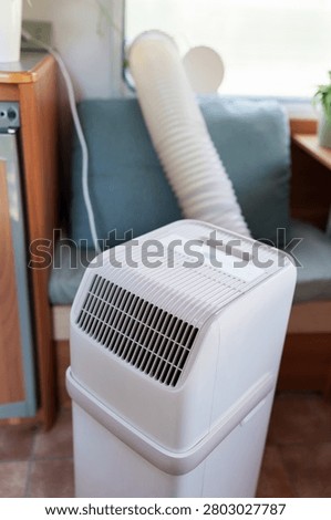 Portable air conditioner unit operating inside a modern camper van during a summer heatwave