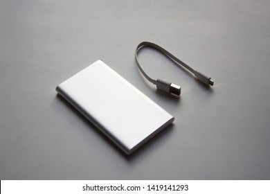 Portable aluminum power bank with USB cable isolated on white background
