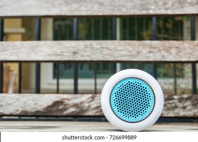 portable Bluetooth wireless speaker on wooden bench for music
