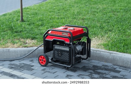 Portable electric generator on the street in summer day. The generator provides with electricity electrical appliances in nature.