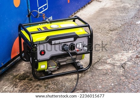 Portable electric generator running in the cold winter.Energy genocide. Power outage as a result of missile strikes by Russia on energy facilities of Ukraine. Small business use gasoline generators.