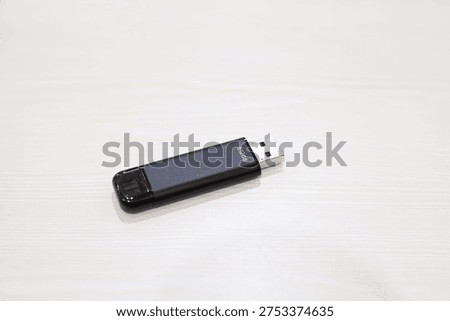 Portable external SSD flash drive on light wooden surface, compact high‑speed data storage device for backup, transfer, and modern digital workflow.